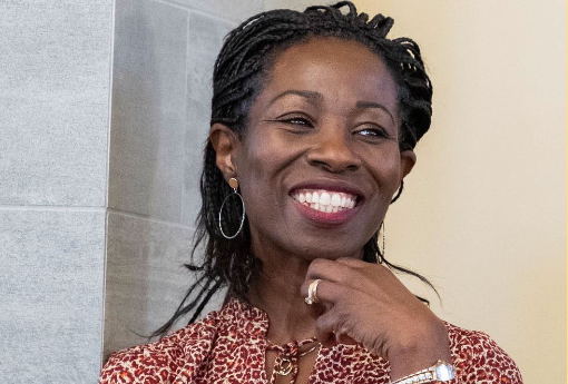 Woman smiles with hand on chin