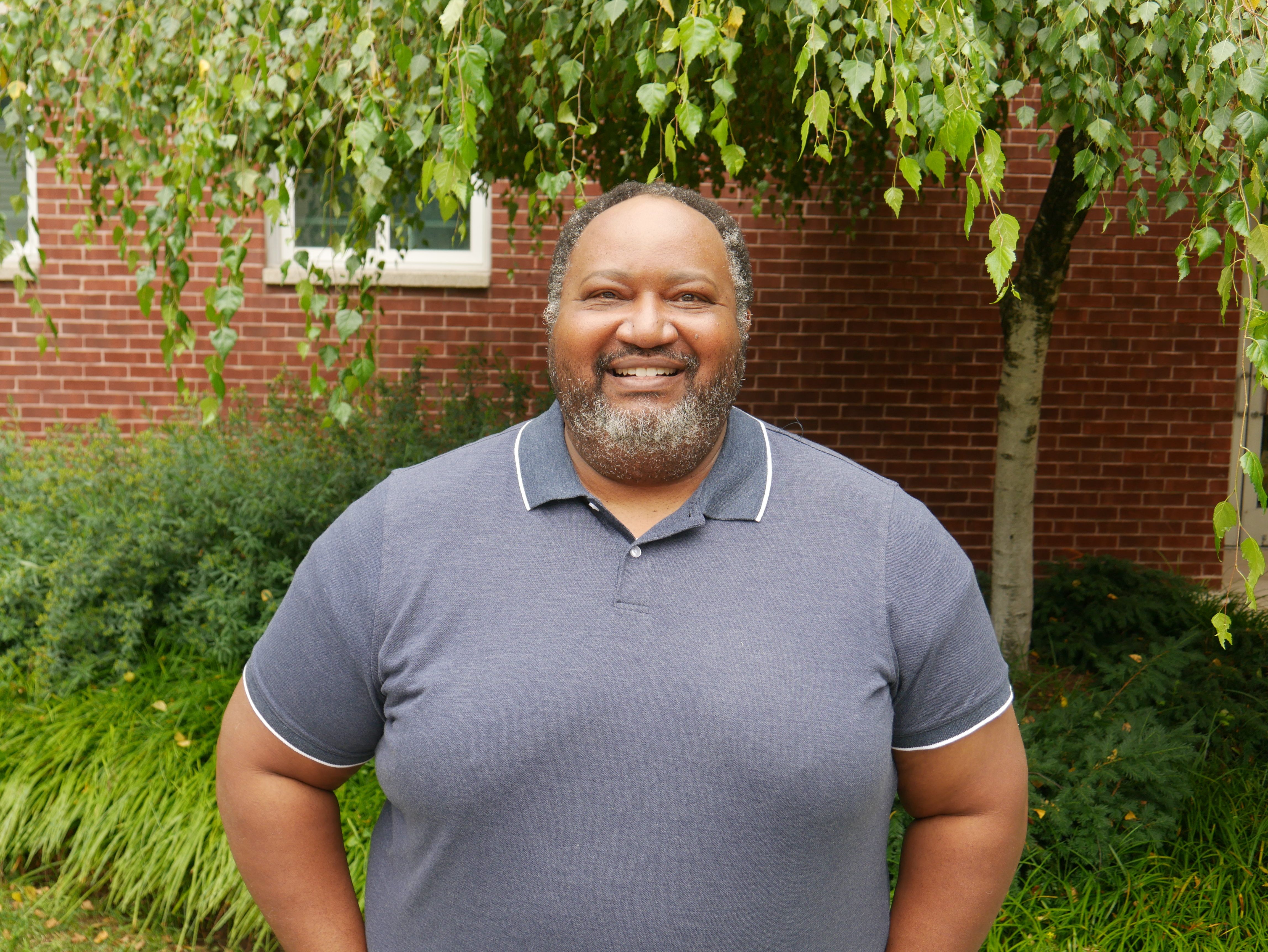 Photo of man smiling outside on campus