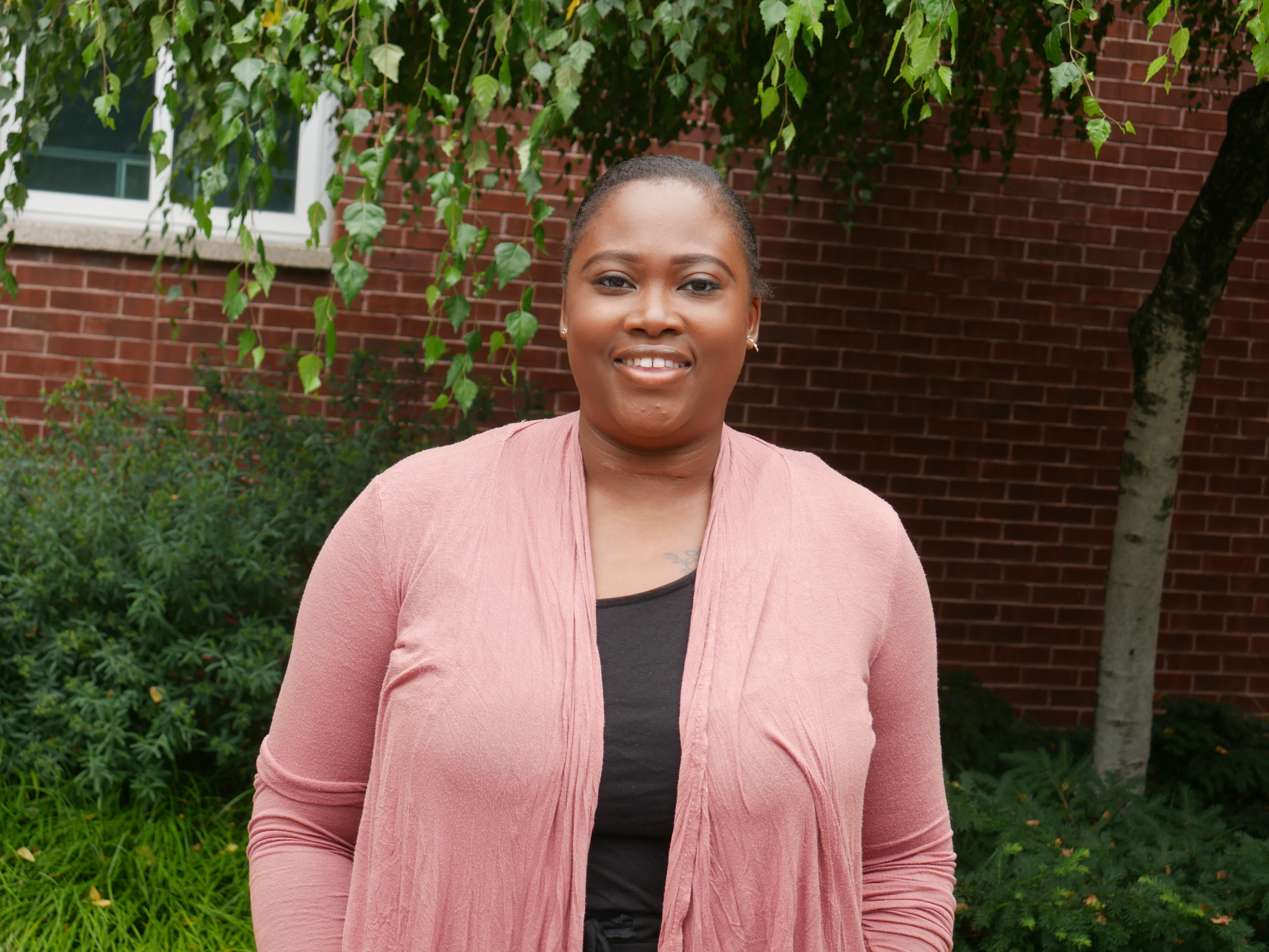 photo of woman smiling outside on campus