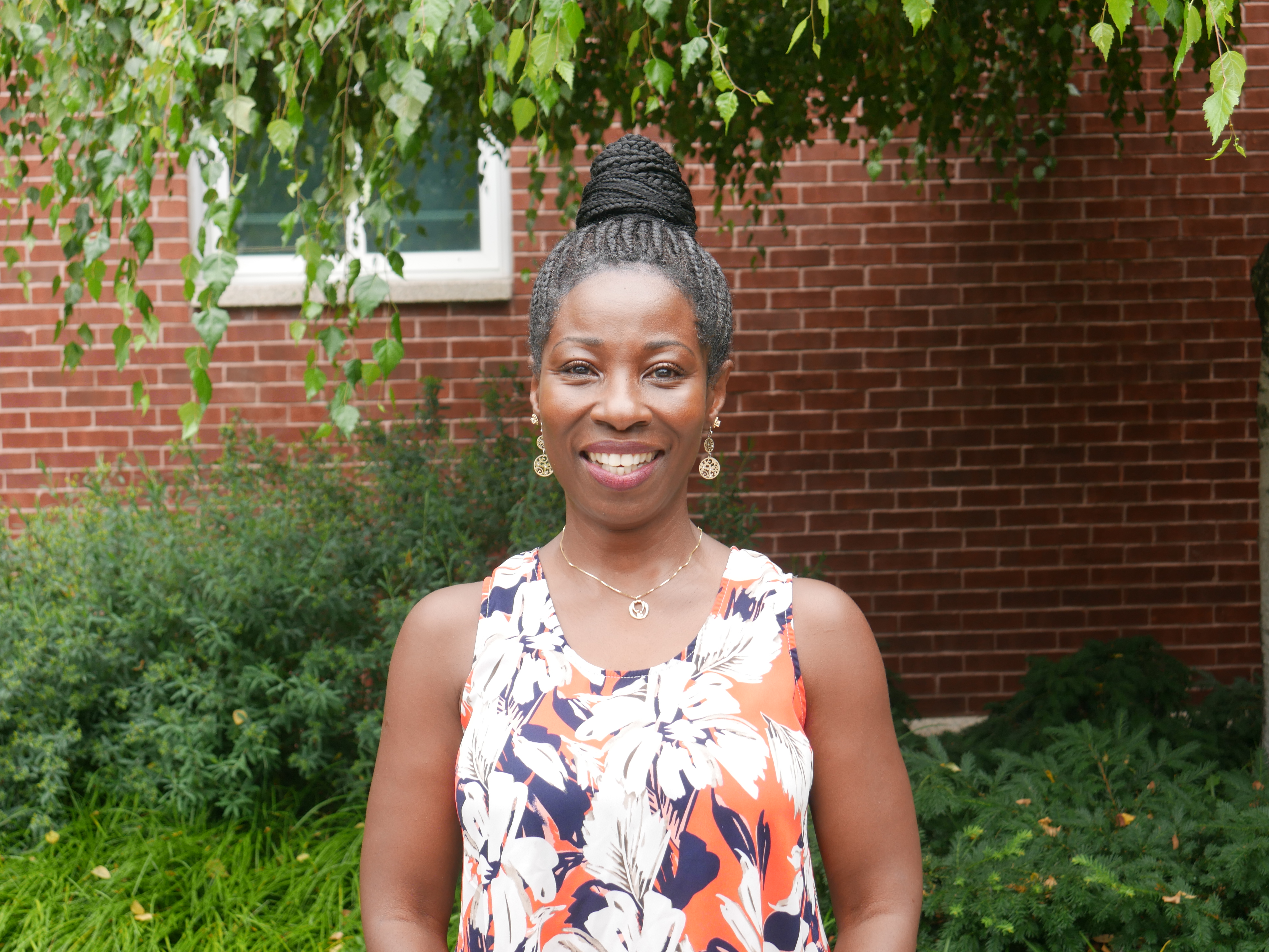 Photograph of woman smiling outside on campus