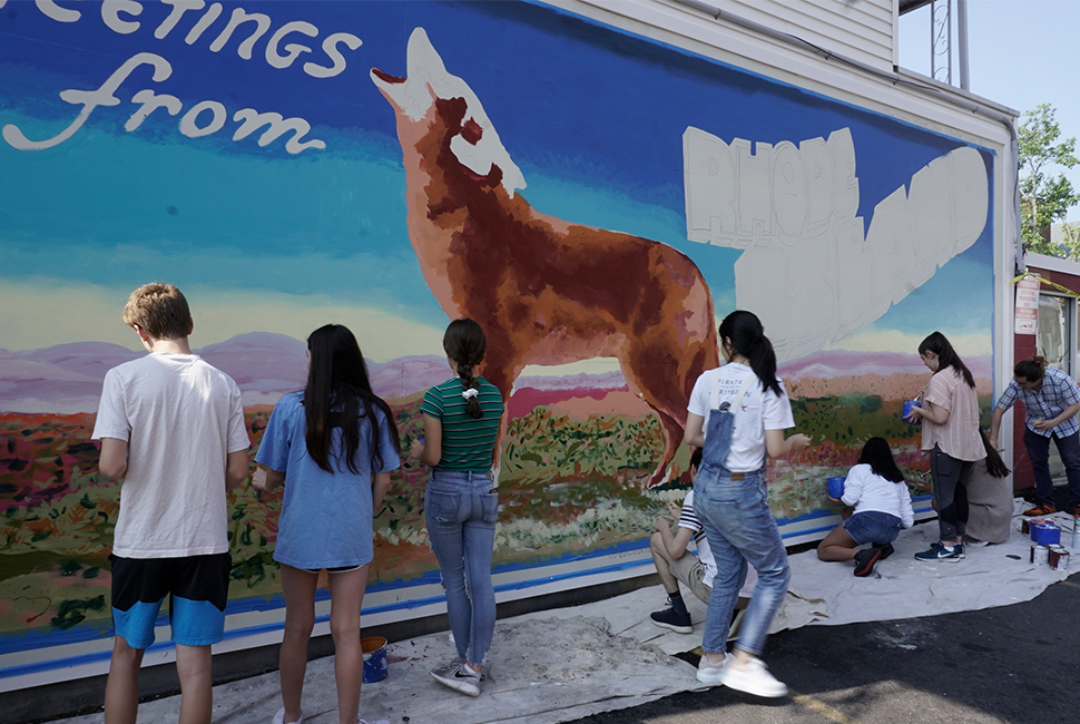 Artists work on an outdoor mural of a howling coyote vintage postcard