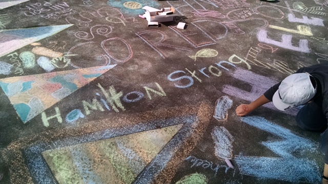 Chalk drawing of the words Hamilton Strong on pavement.