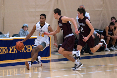 DJ Smith dribbles past opponents on his way to earn 1,000 points at Wheeler.