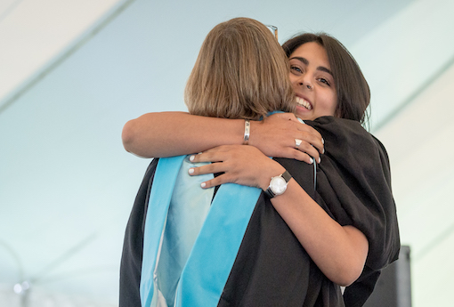 Graduating senior hugs a teacher during the ceremony.