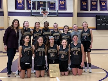 Middle School Girls Basketball team with trophy.
