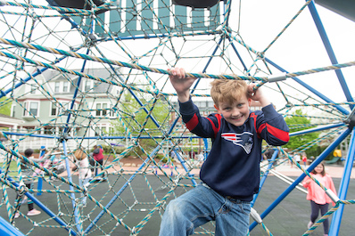 Boy plays on outdoor play equipment