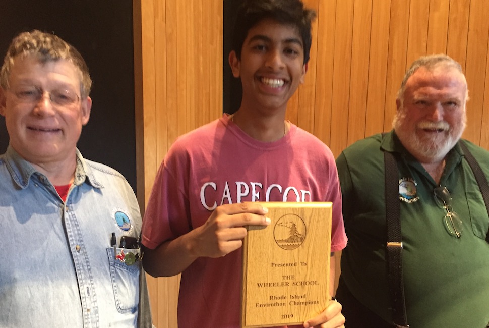 Two men flank a student holding a plaque for a state championship award at the Envirothon.