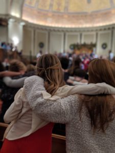 Students sway to the music and hug at the annual Holiday Festival.
