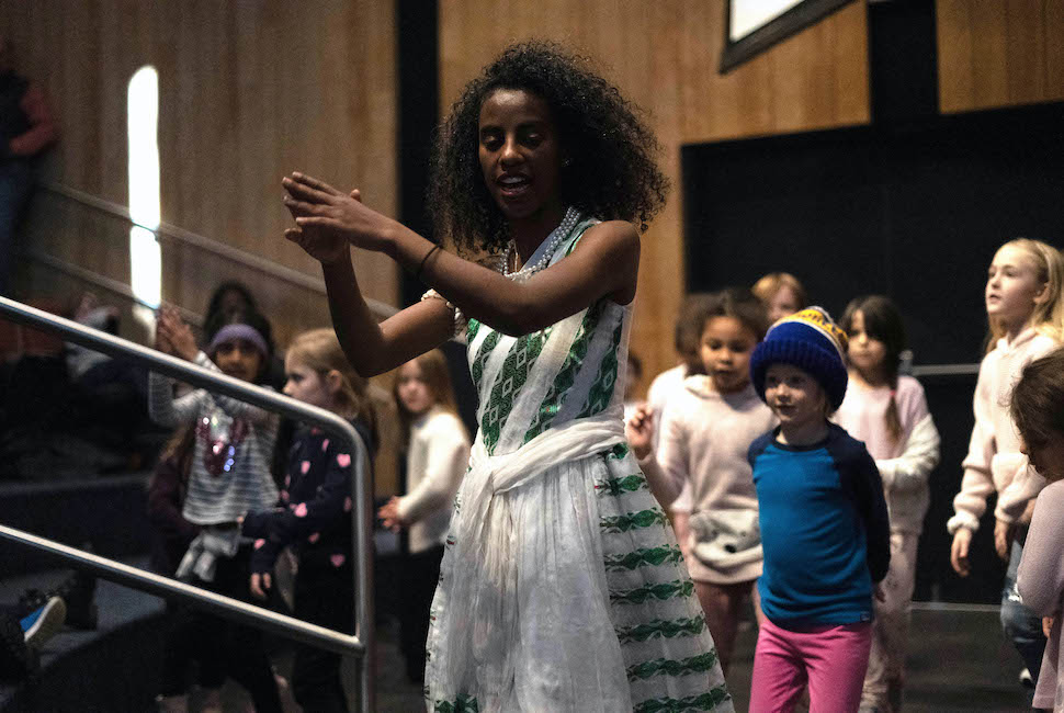 African dance leads young children in learning a dance.