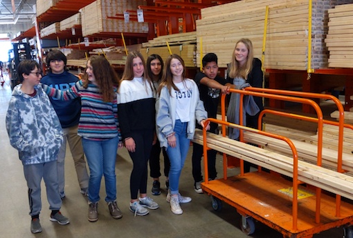 Eight 8th-graders with wall studs at a Home Depot.
