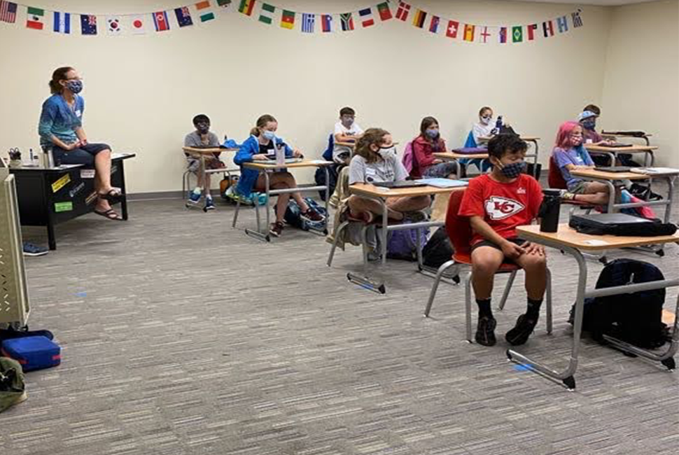 A teacher and Gr. 6 class sitting in their new classroom at the Farm Field House.