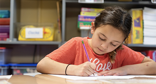 Young girl writing in a notebook.