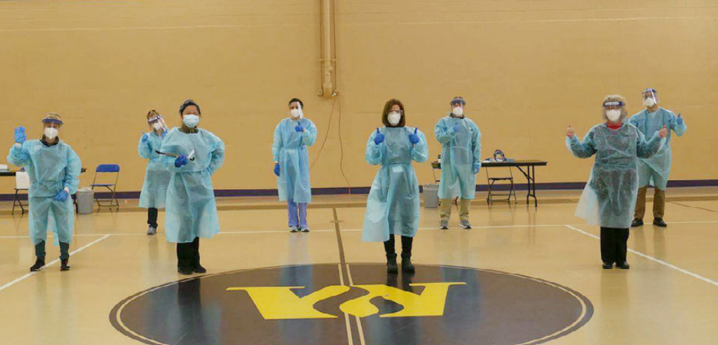 a group of health care workers posing in a gymnasium 