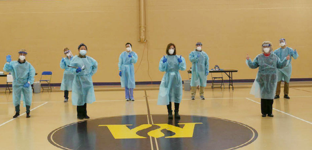 a group of health care workers posing in a gymnasium
