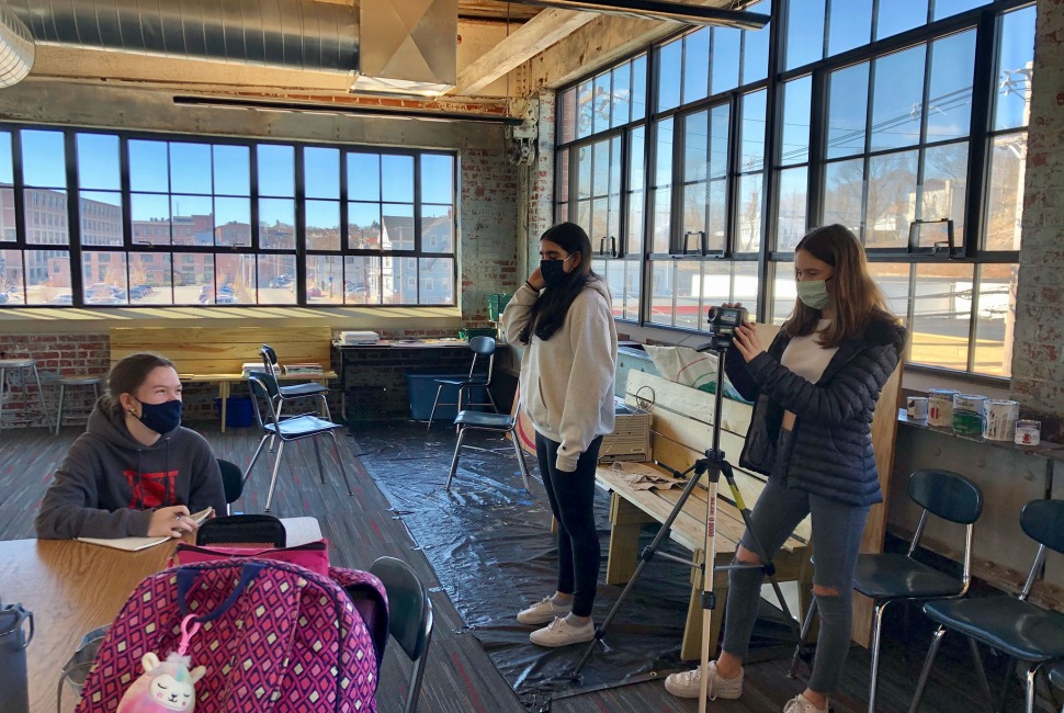Three 8th grade girls work on a project inside an old mill in Providence converted to a classroom.