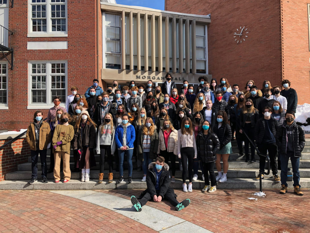 Class of 2021 with masks on standing on steps of Morgan Hall for a class photo.