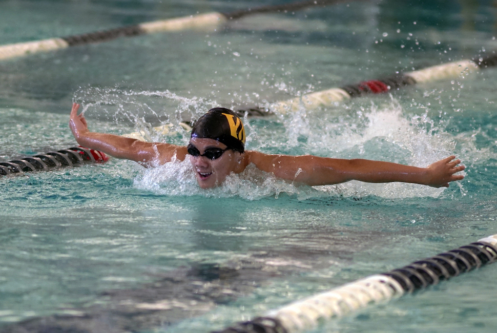Male athlete swimming butterfly event with Wheeler W swim cap.