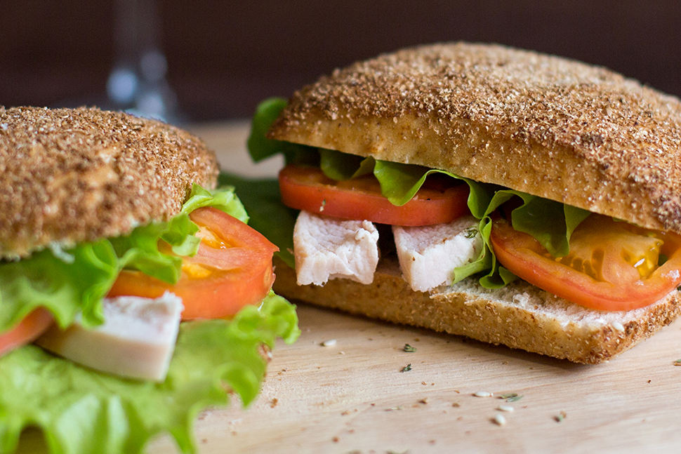 A close image of a chicken, tomato, and lettuce sandwich.