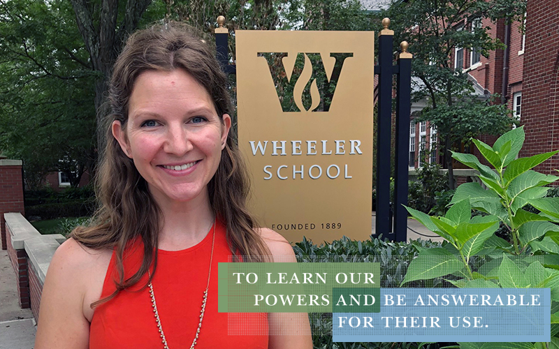 Enrollment Director Anna Curtis standing in front of the Wheeler School sign outside the front of the building and smiling at the camera.
