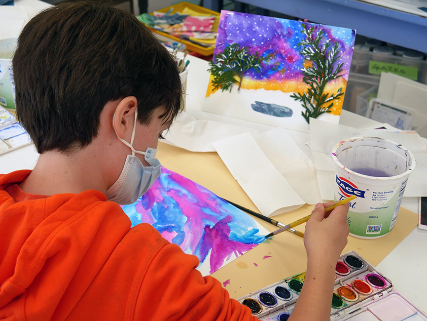 A 4th-grade student paints their holiday card.