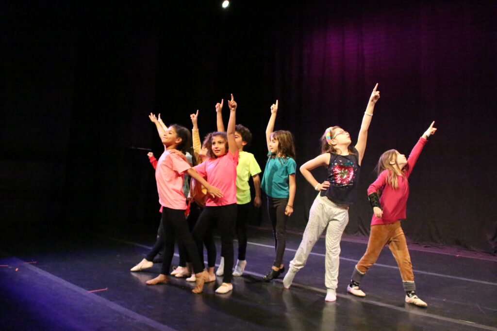 Lower School students rehearsing for their dance recital on stage.