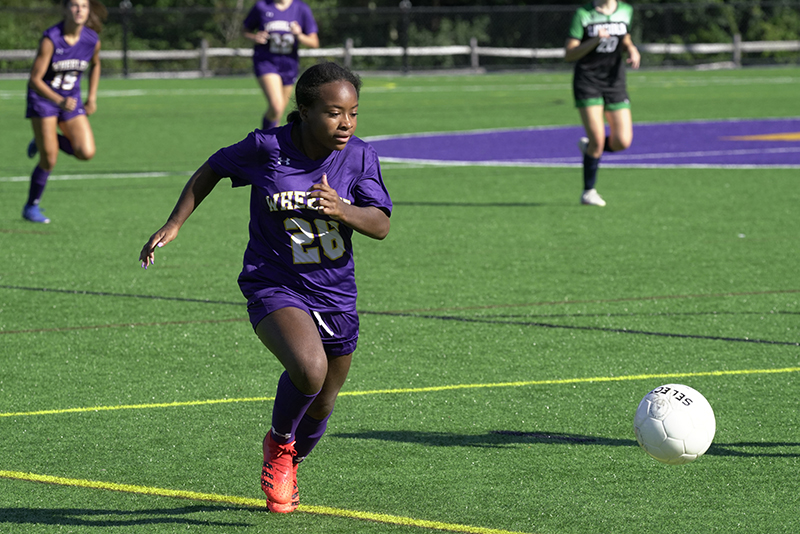 A member of the girls soccer team runs after the ball during a game.