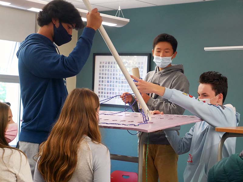 Students in 10th-grade History class build (and operate as) a large-scale sewing machine.