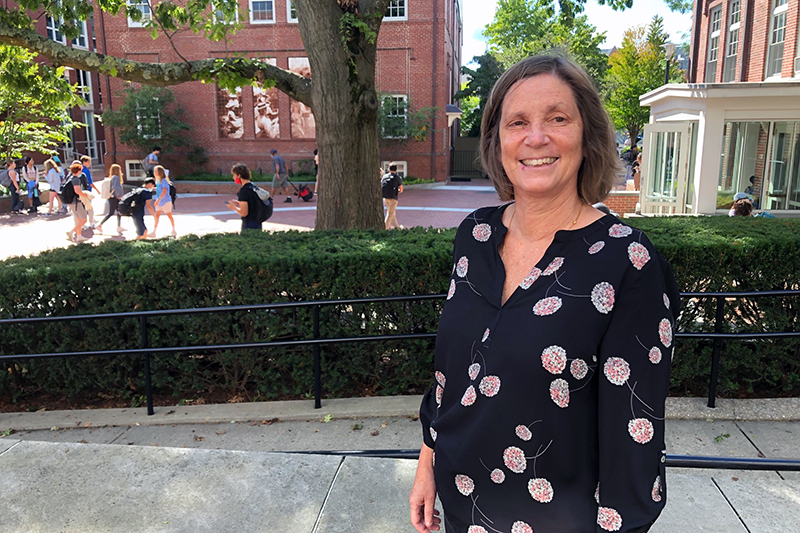 Upper School Head Neeltje Henneman stands outside on the Wheeler campus. She is smiling a the camera.