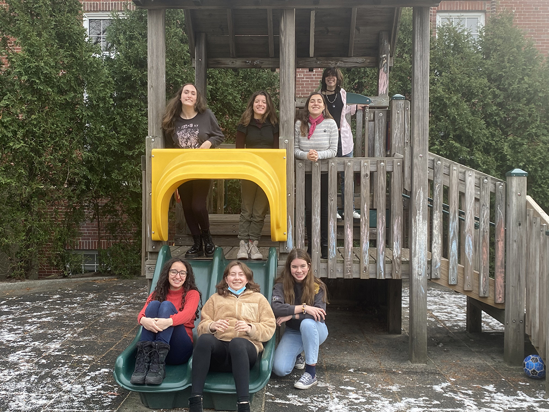 Members of the Ensemble 10 theater group pose on playground equipment for a photo at Wheeler School.
