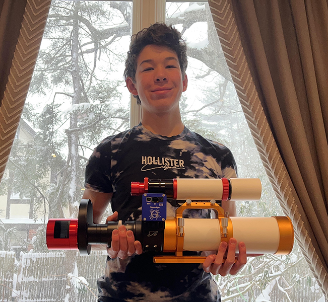 Griffin Haisman '25 stands with his astrophotography equipment he uses to take photos of space with.