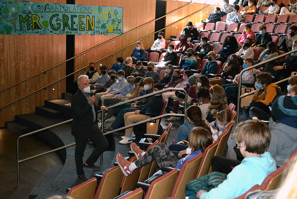 Jon Green stands at the front of an auditorium speaking to Hamilton students, faculty, staff, and alumni.