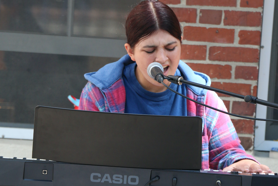 Student singing and playing the keyboard during a cafe series performance.
