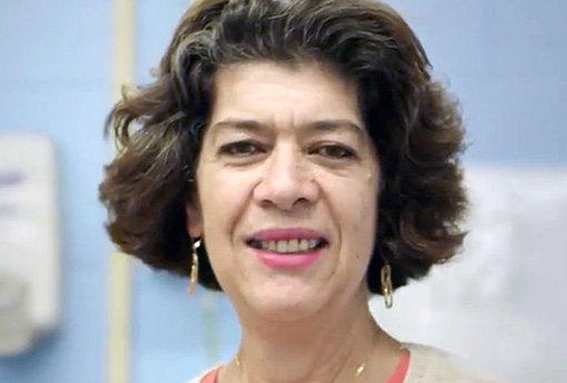 Photo of Patricia Martinez smiling at the camera. There is a blue wall behind her.}