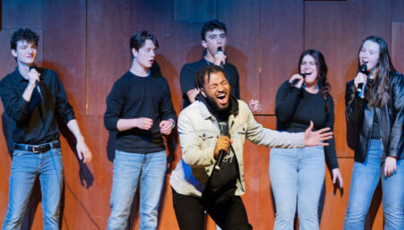 Members of the 18 Wheelers acapella team singing during a performance.
