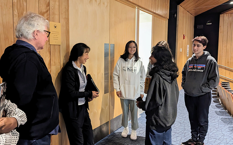 Photo of Wang Ping engaging with a group of Upper School students and answering questions in the Gilder Center for the Arts' Isenberg Auditorium.