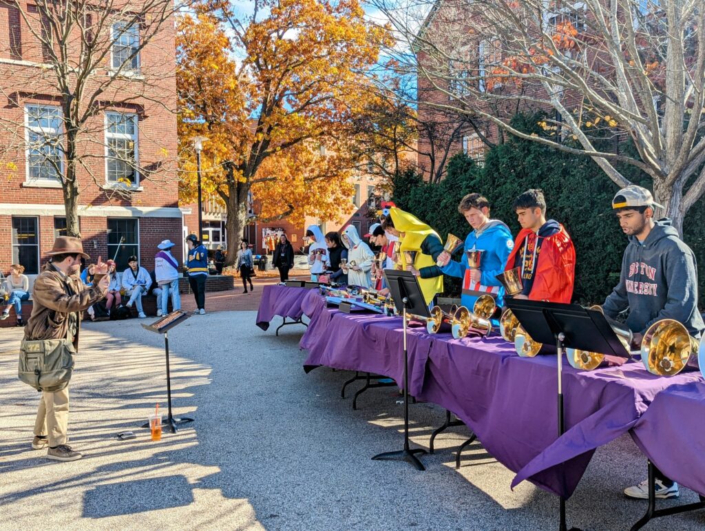 Students dressed as chickens, a swimmer, a cowboy, a superhero duo, a baby boomer, and bananas convened in Creamer Courtyard for a mini handbell concert during lunchtime.